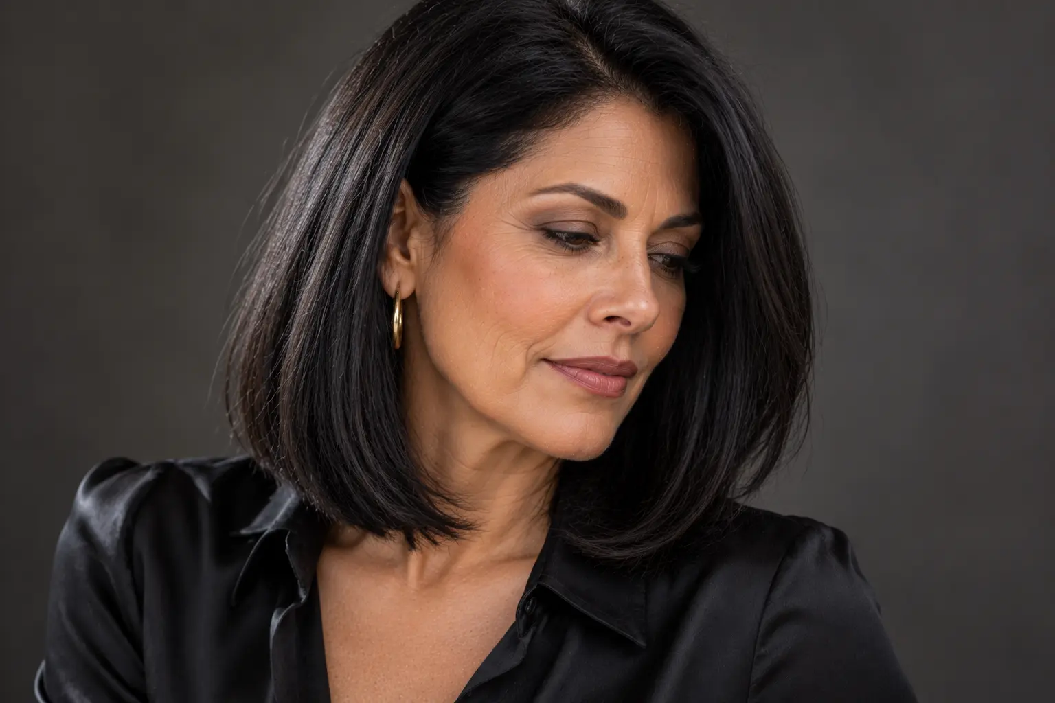 Sleek long layered bob haircut with smooth, subtle layers on a mature woman over 50